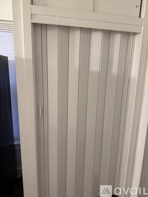 A white vertical blinds on a window.