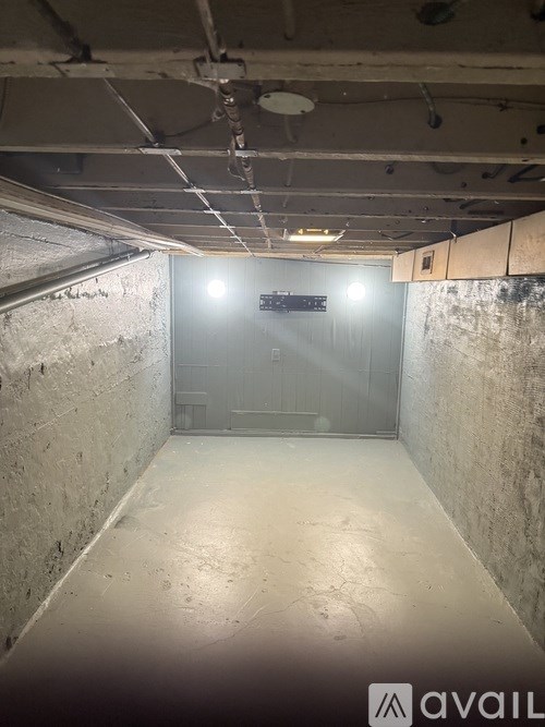 A dimly lit tunnel with a sign that reads "avail" at the end.