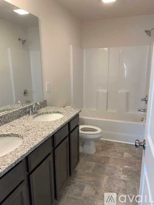 A bathroom with a toilet, sink, and bathtub.