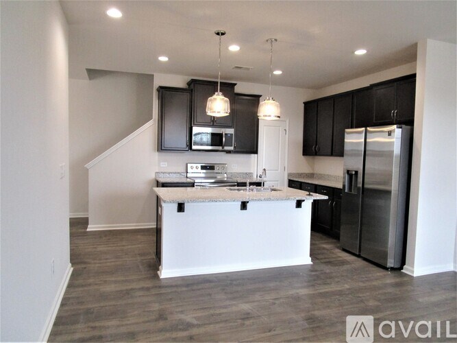 A modern kitchen with a white island and stainless steel appliances.