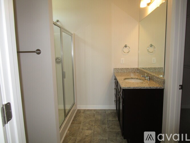 A bathroom with a sink, mirror, and shower.