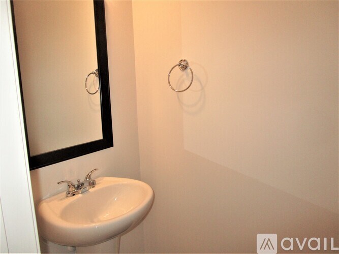 A white sink with a silver faucet is under a mirror in a bathroom.