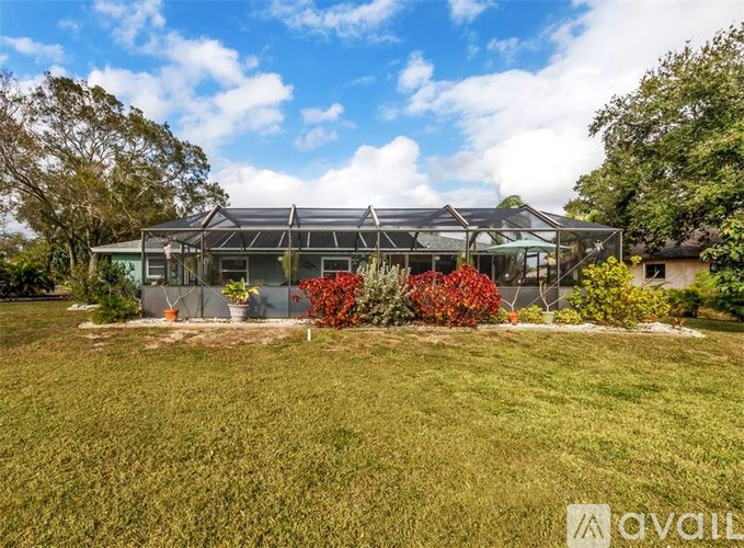 A house with a glass roof and a green lawn in front.