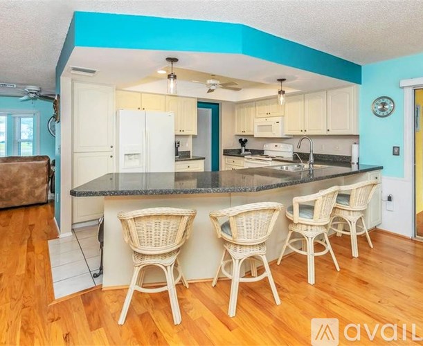 A kitchen with a counter and chairs.