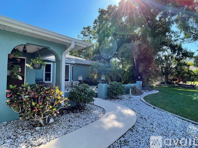 A house with a garden and a gravel path leading to the front door.