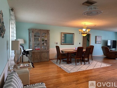 A living room with a wooden table and chairs.