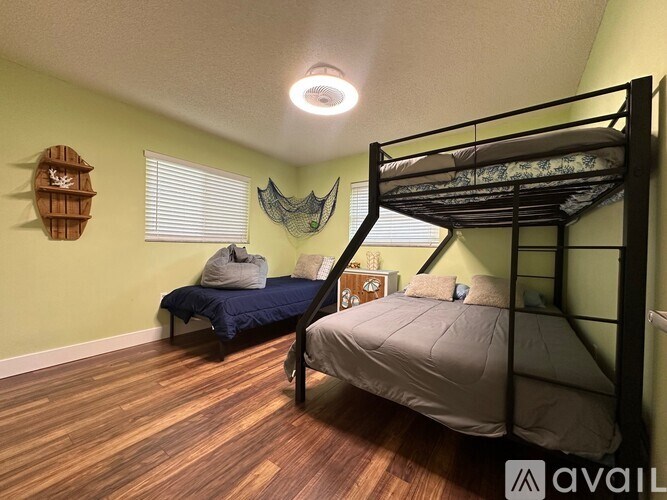 A room with a bunk bed and a single bed with pillows and blankets.