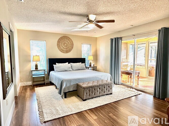 A bedroom with a bed, nightstands, and a ceiling fan.