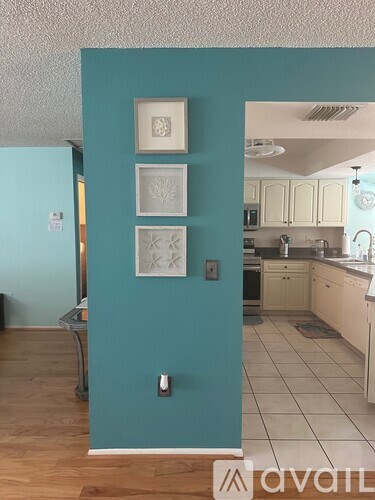 A kitchen with a blue wall and white cabinets.