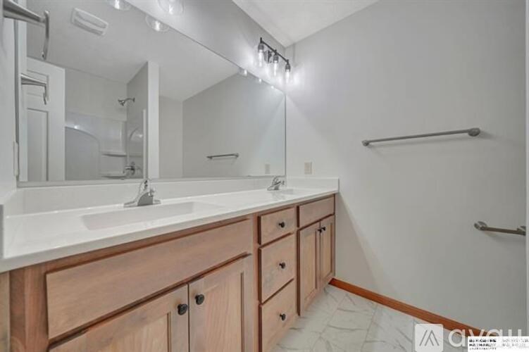 A bathroom with a sink, mirror, and wooden cabinets.