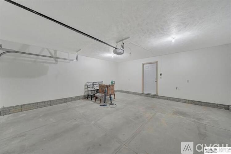 A room with a concrete floor and white walls is shown.