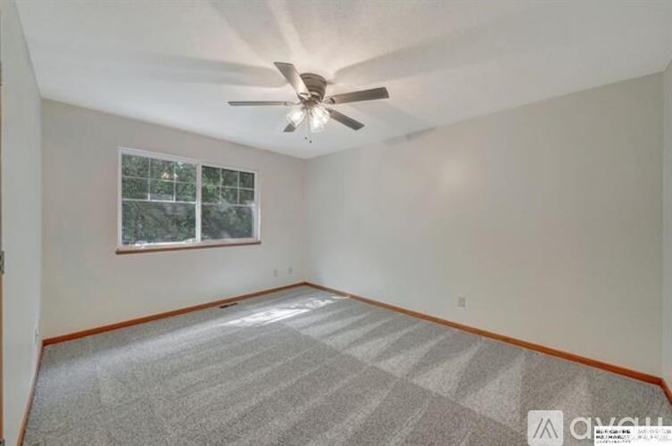 A room with a ceiling fan and a window.