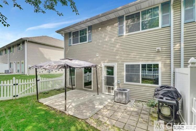 A patio with a table and chairs is covered by a white umbrella.