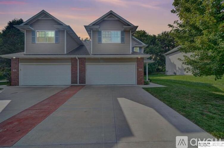 A house with a grey roof and two garages.