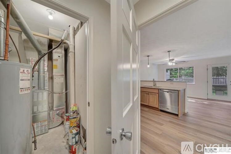 A room with a doorway leading to a kitchen area.