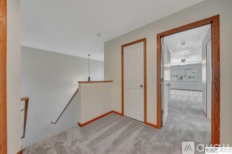 A hallway with a staircase and two doors.