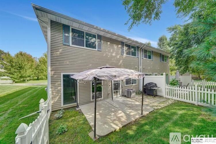 A house with a patio and a white picket fence.