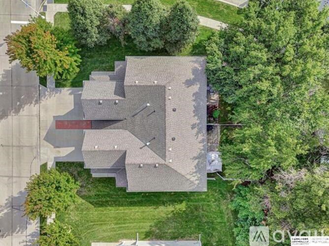 A house with a red roof is surrounded by trees.