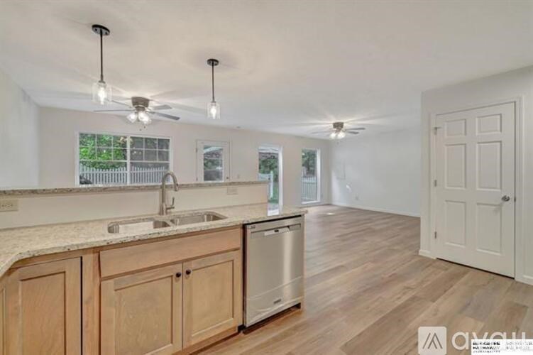 A kitchen with wooden cabinets and a marble countertop.