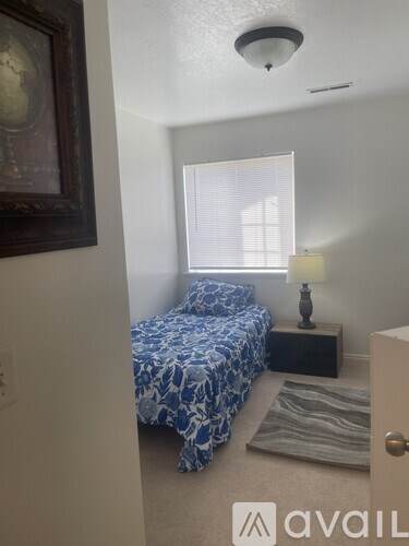 A bedroom with a bed, nightstand, and lamp.