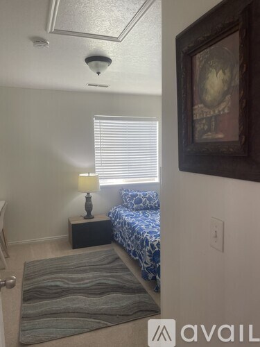 A bedroom with a bed, nightstand, and lamp.