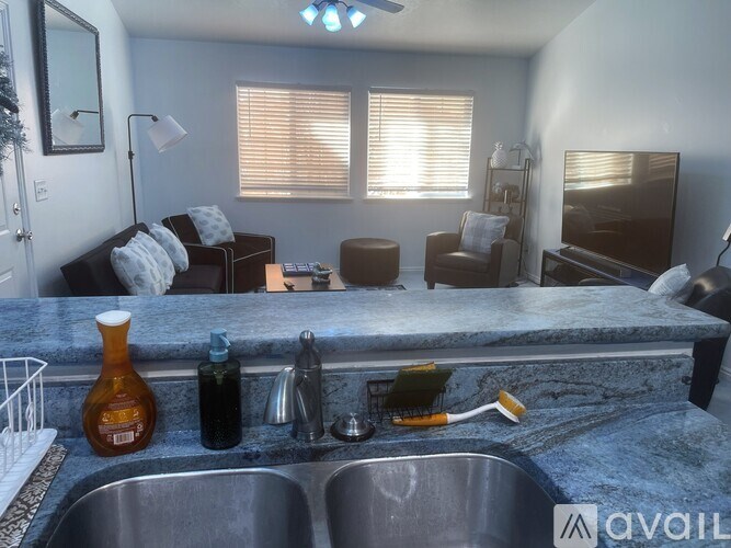 A kitchen with a marble countertop and a sink.