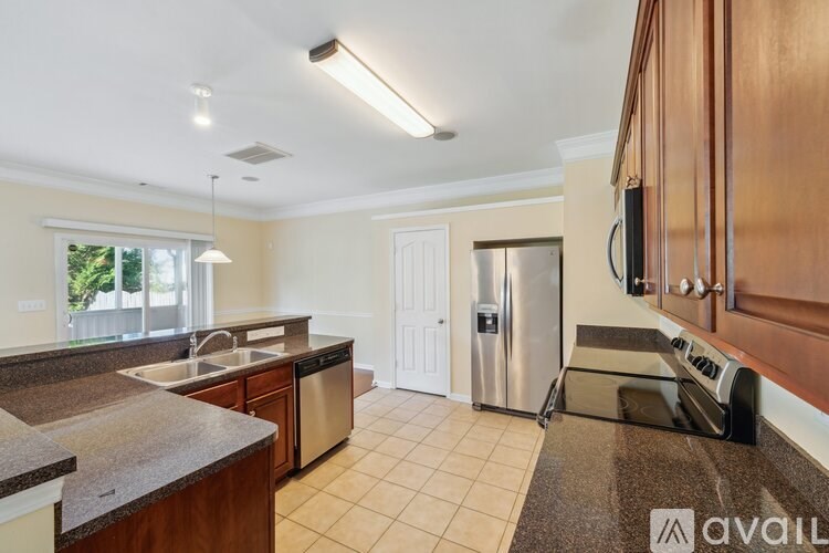 A kitchen with a granite countertop and stainless steel appliances.
