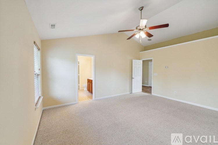 A room with a ceiling fan and carpeted floor.