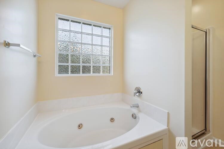 A bathroom with a tub and a window.
