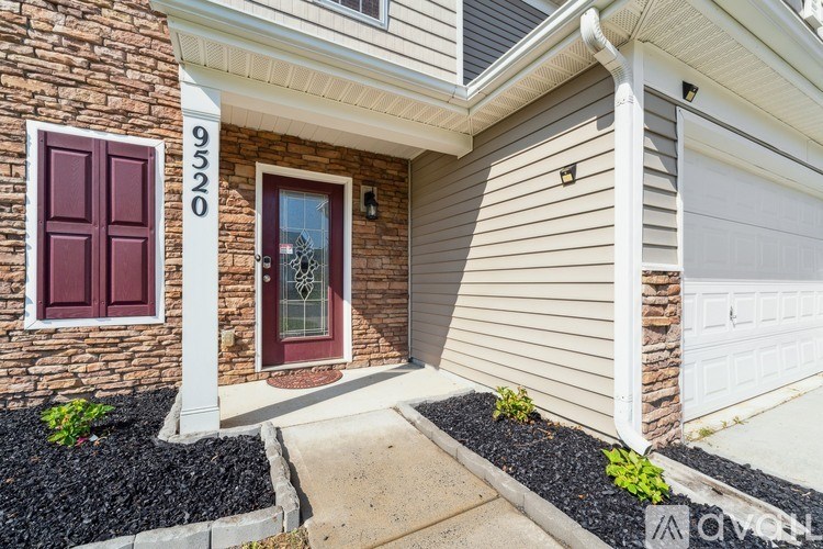 A house with a red door and a white garage door.