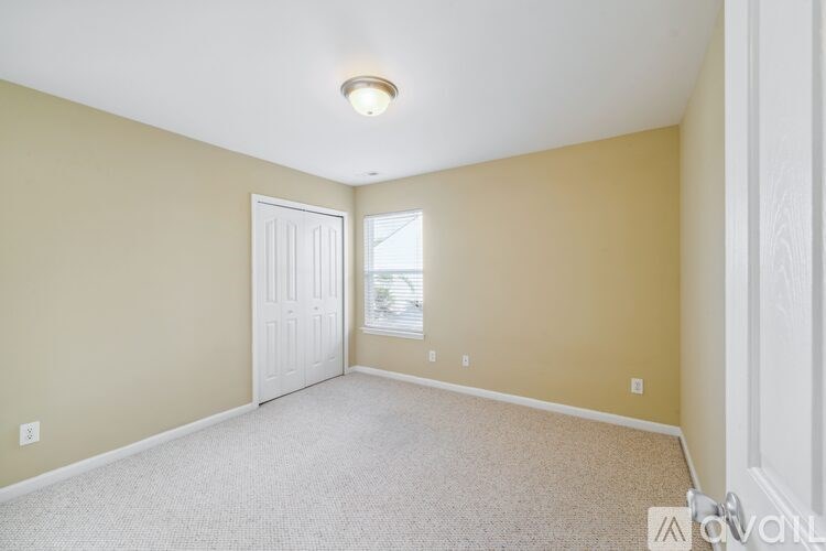 A room with a white door and carpeted floor.