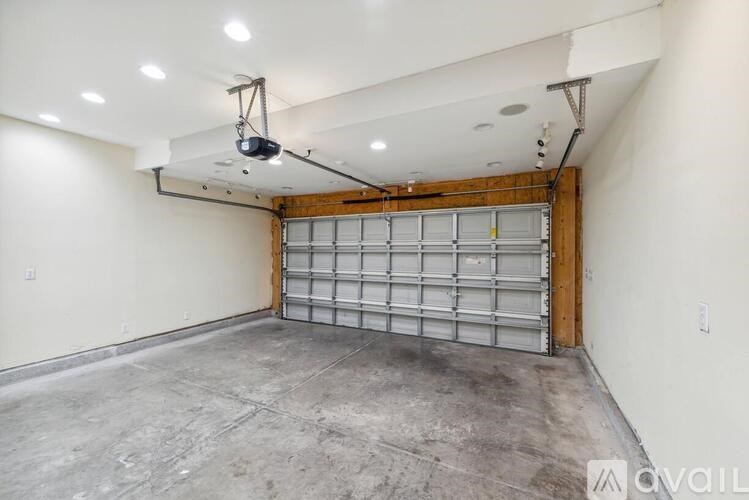 A large garage with a metal door and a hanging light fixture.