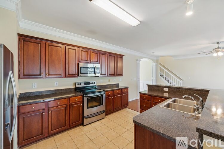 A kitchen with wooden cabinets and a granite countertop.