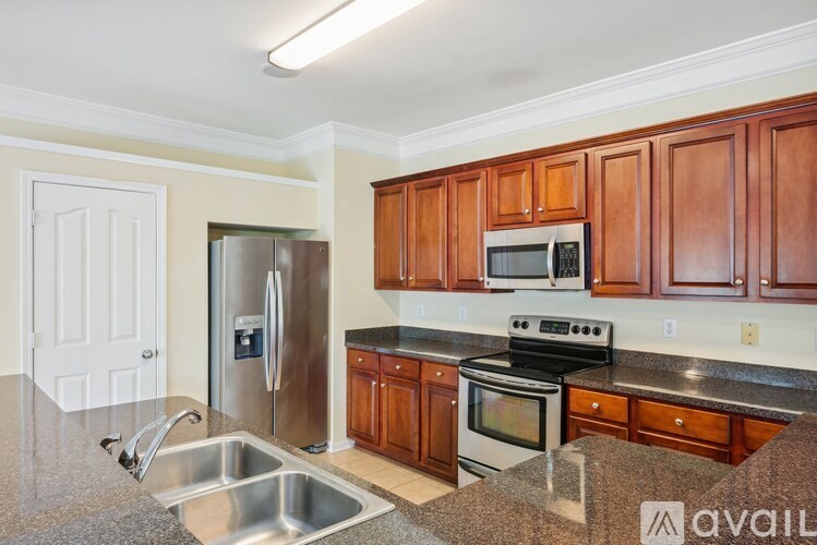 A kitchen with wooden cabinets and a stainless steel refrigerator.