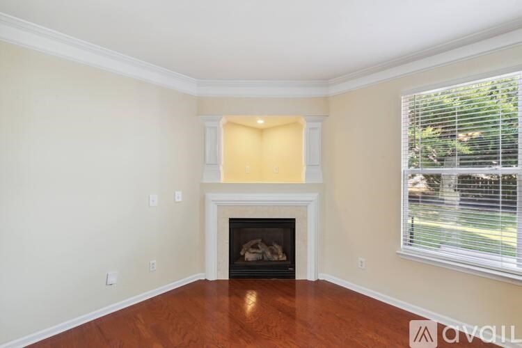 A room with a fireplace and a window with blinds.