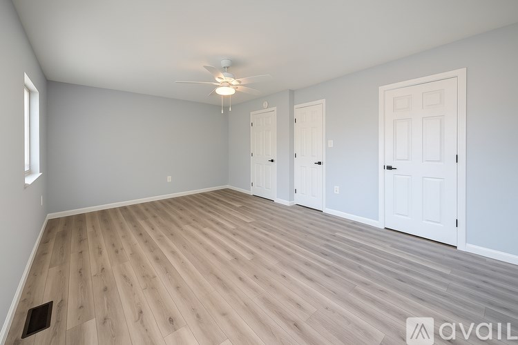 A room with wooden flooring and white doors.