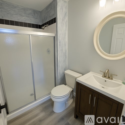 A bathroom with a toilet, sink, and shower.