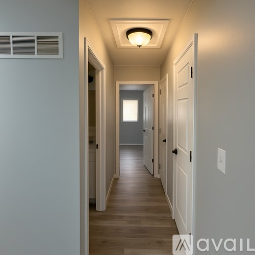A long hallway with doors on both sides and a light on the ceiling.