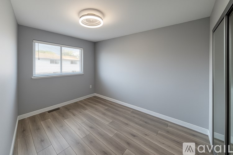 A room with a window and wooden flooring.