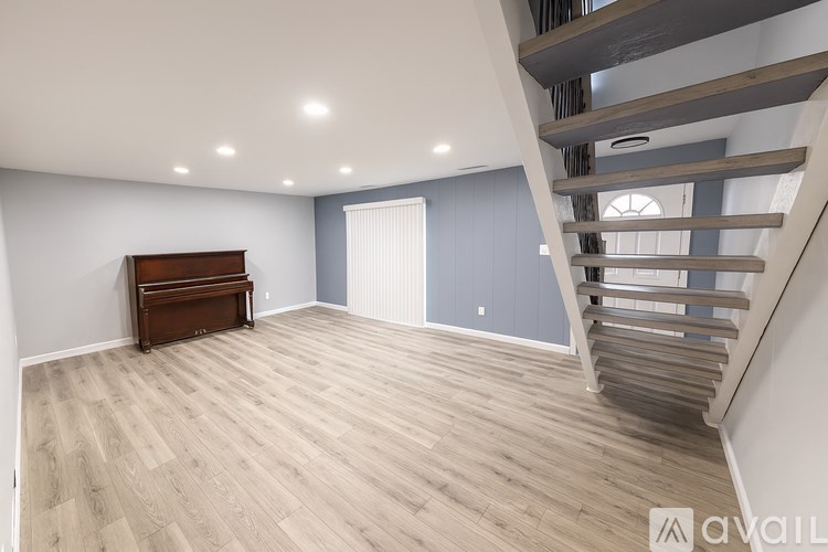 A room with a wooden bench and a staircase.