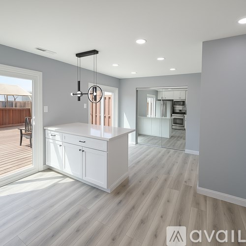 A modern kitchen with a large island and a dining area.