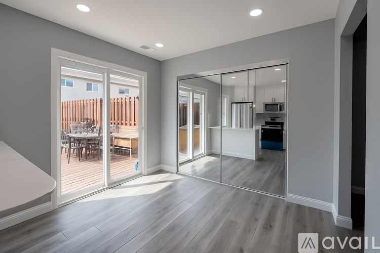 A spacious room with a large mirror on the wall.