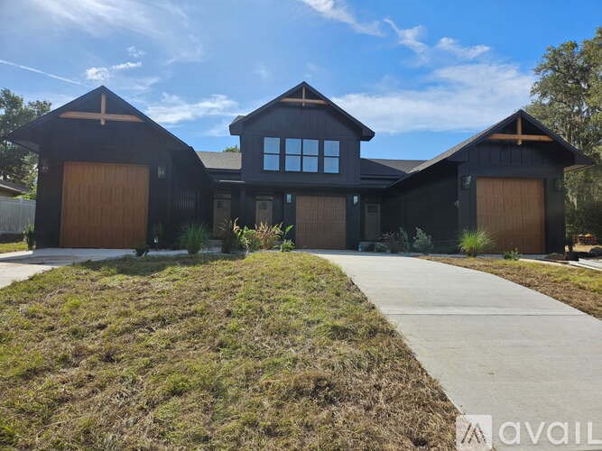 A large house with a garage door and a driveway in front.