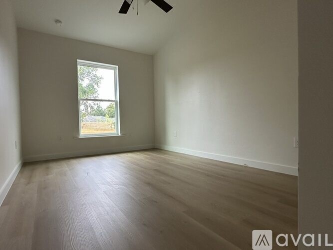A room with a window and a ceiling fan.