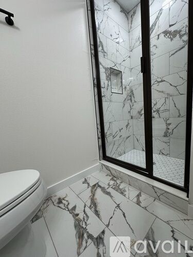 A bathroom with a marble floor and a toilet.