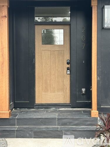 A black door with a wooden frame and a glass window.