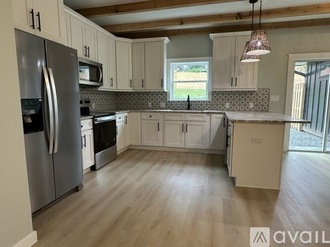A kitchen with a refrigerator, oven, and microwave.