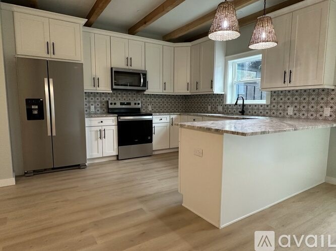 A kitchen with wooden floors and a marble countertop.