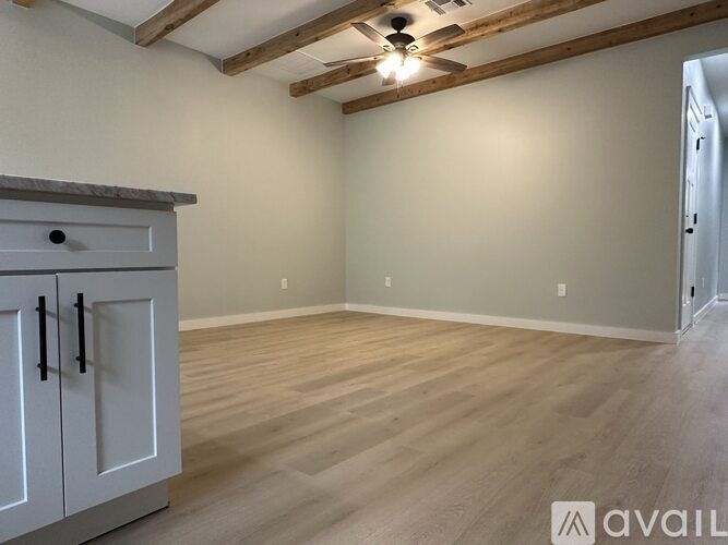 A room with wooden flooring and a cabinet with a drawer and handles.