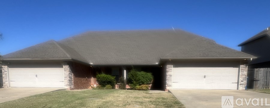 A house with a grey roof and two garages.